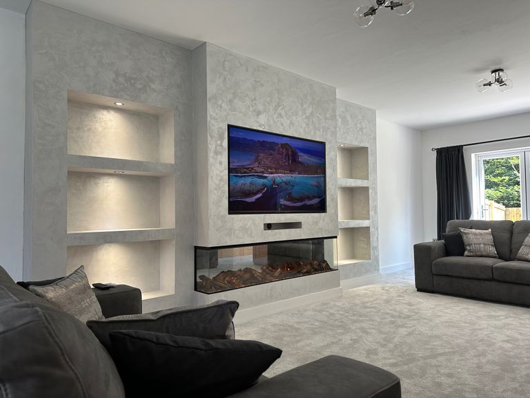 Bespoke slat media wall with fire-effect TV and built-in shelving by Dyson Joinery